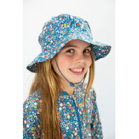girl wearing Ditsy Blue Swim Hat smiling
    		